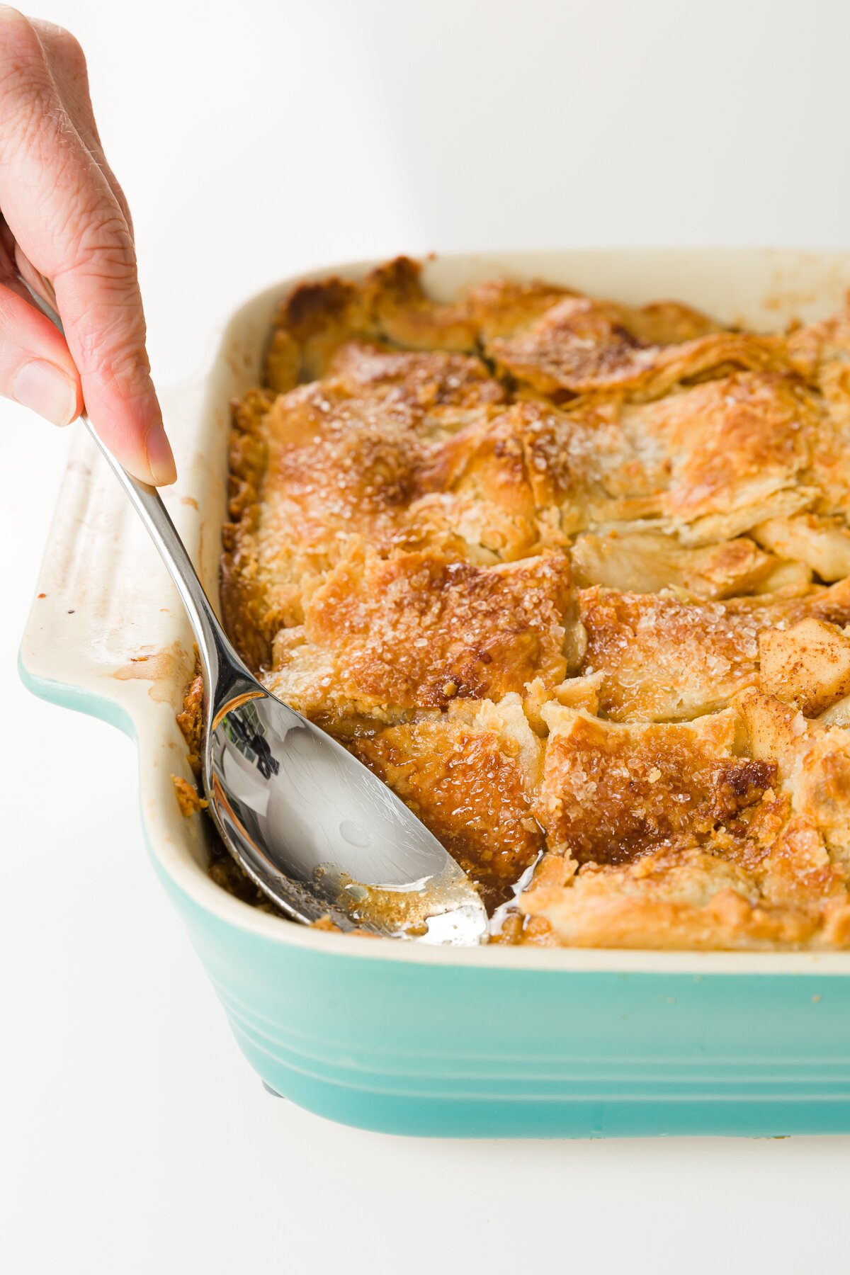 pushing pie crust into pan using the back of a spoon