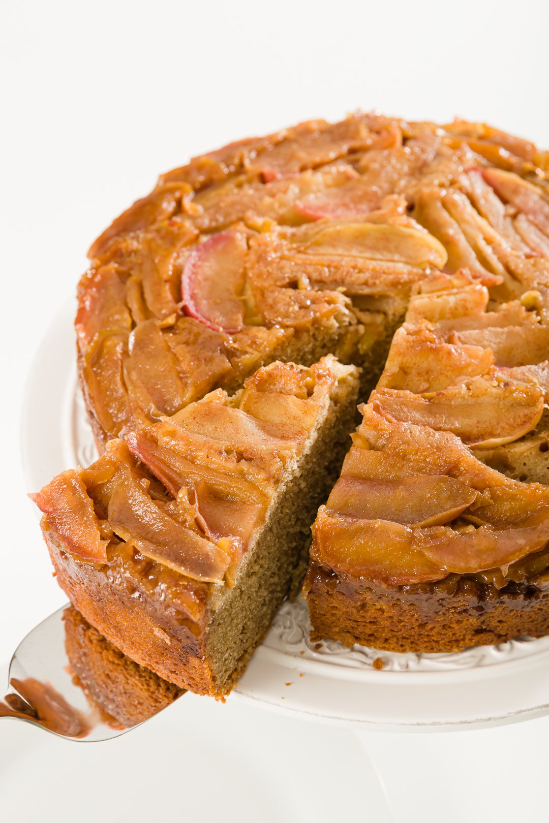 Apple upside-down cake with a slice pulled out on a cake server