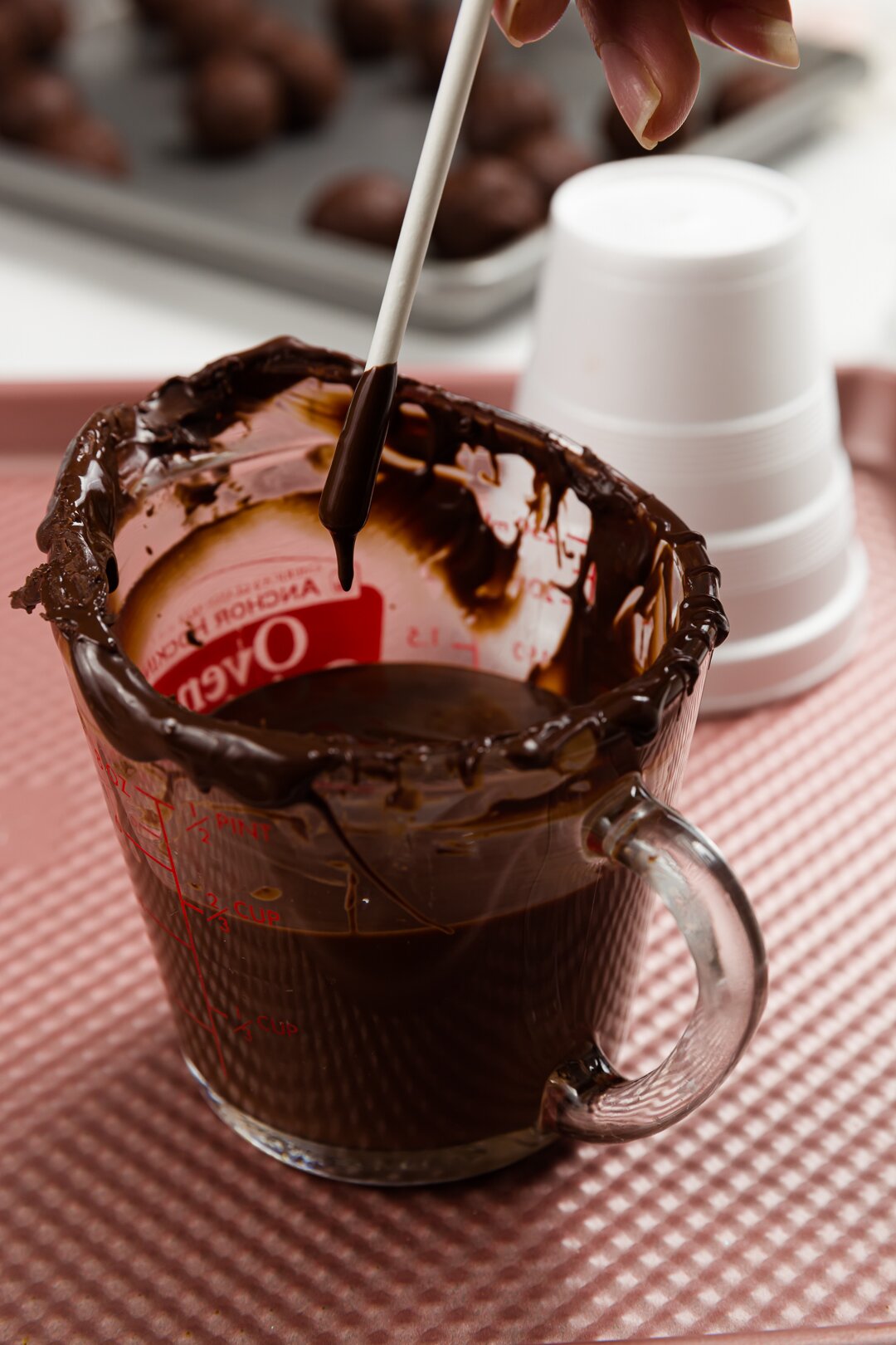 Dipping lollipop stick in chocolate