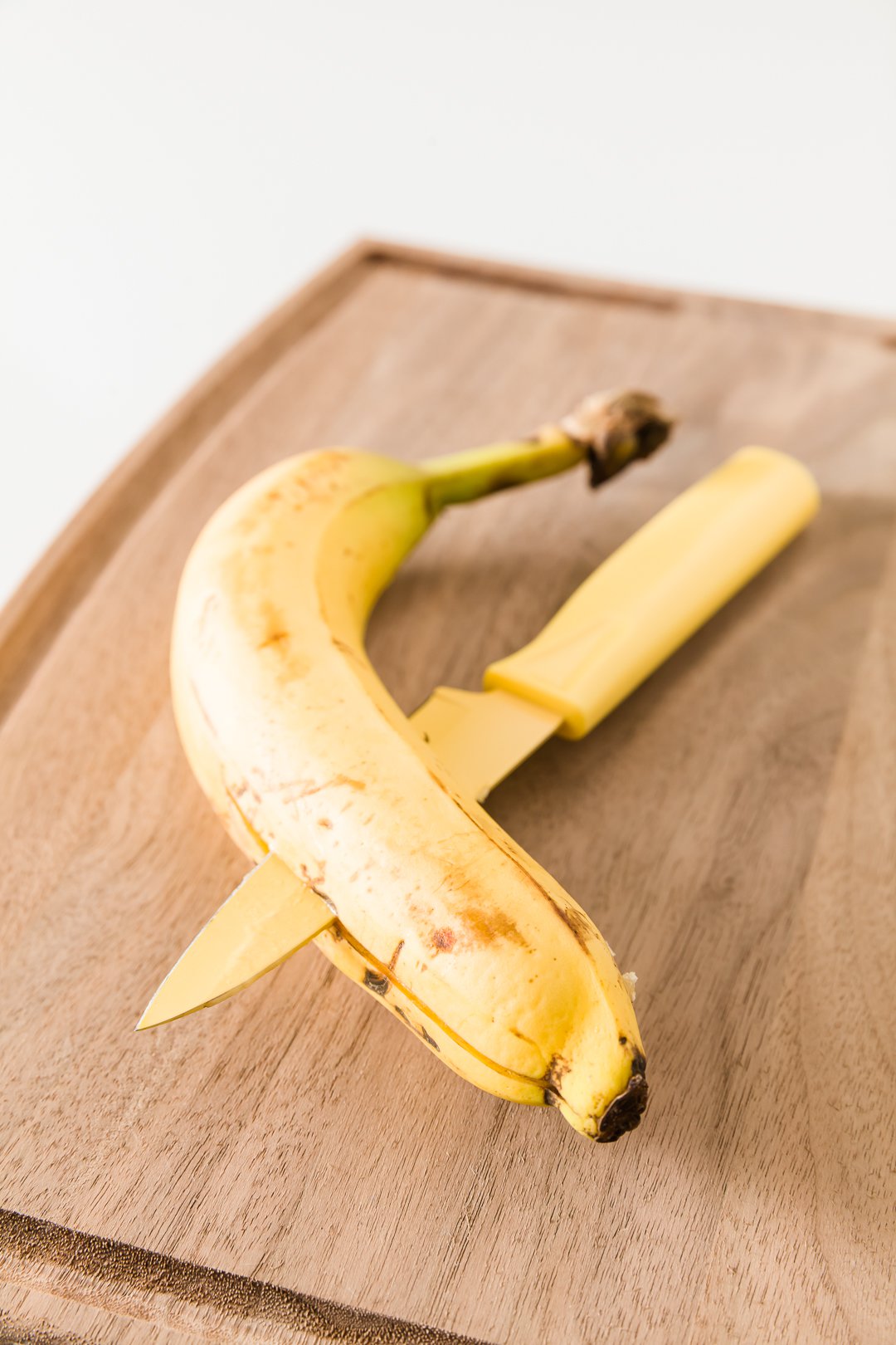 A knife slicing a banana