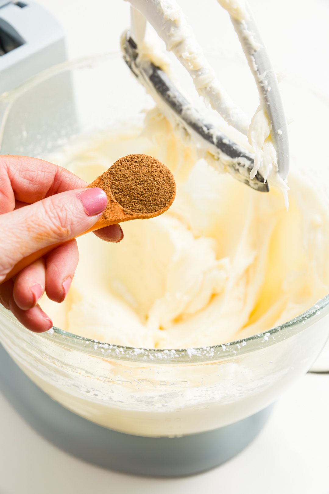 adding cinnamon to the cinnamon cream cheese frosting