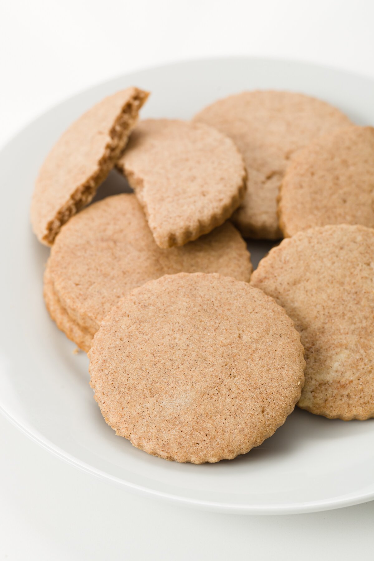 Plate of cookies with one broken in half on the back of the plate