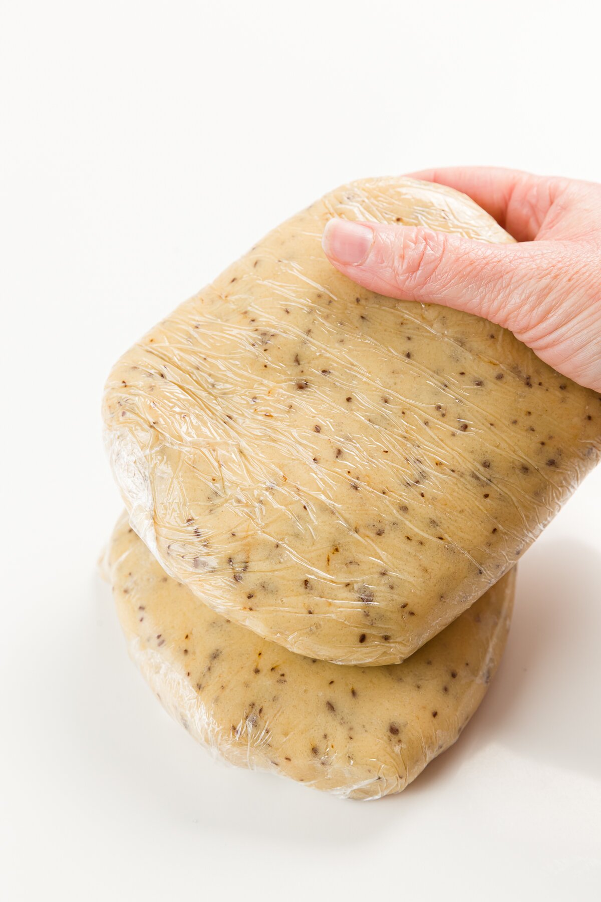 Two discs of coffee cookie dough in plastic wrap