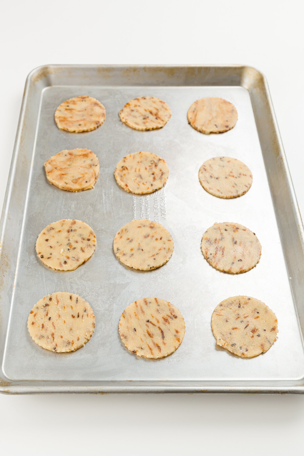 16 coffee cookies on a cookie sheet ready to go in the oven