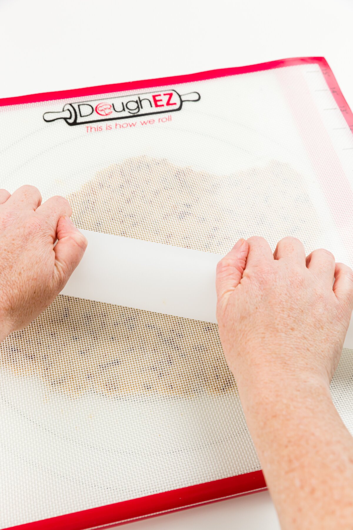 Rolling out coffee cookie dough between two silicone mats