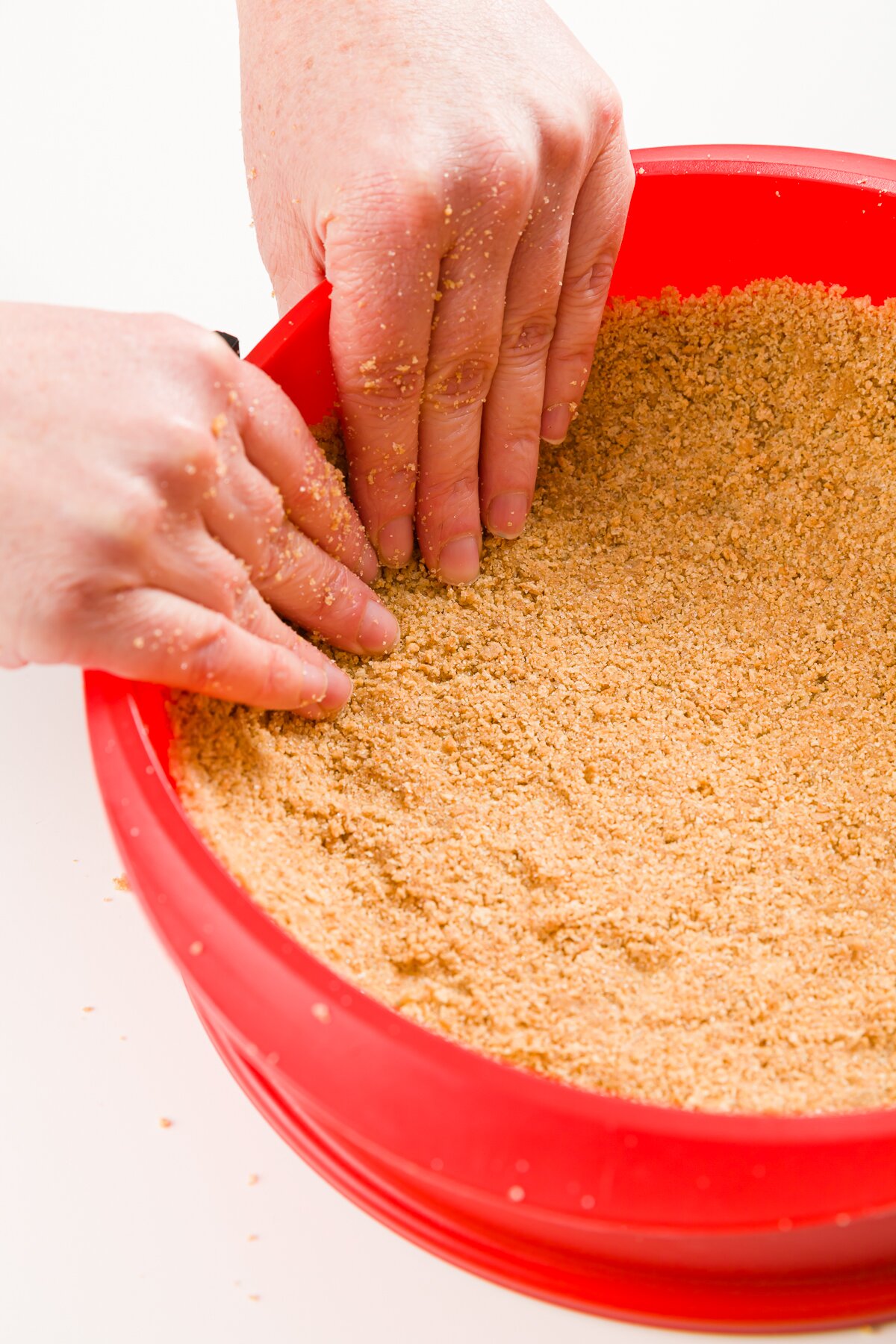 Pressing gingersnap crust into a springform pan