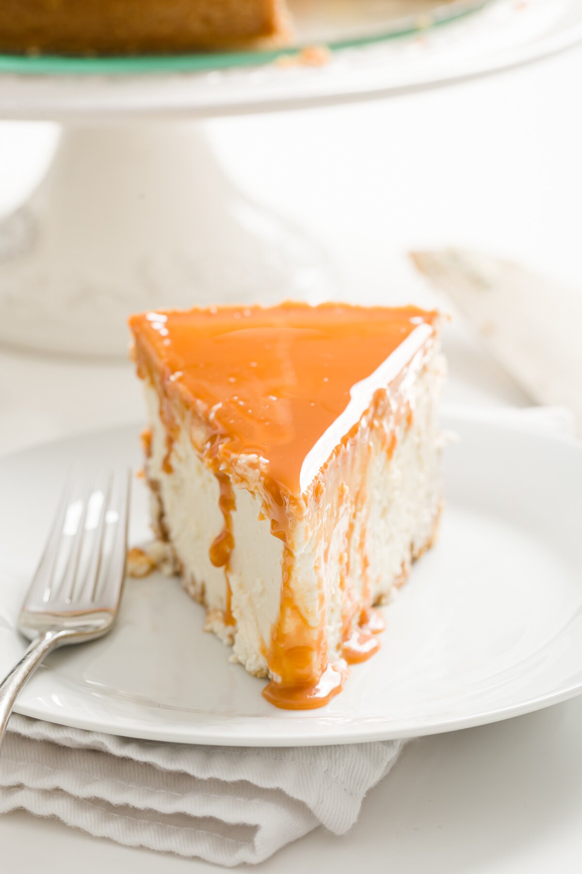 slice of cheesecake with dulce de leche dripping down it