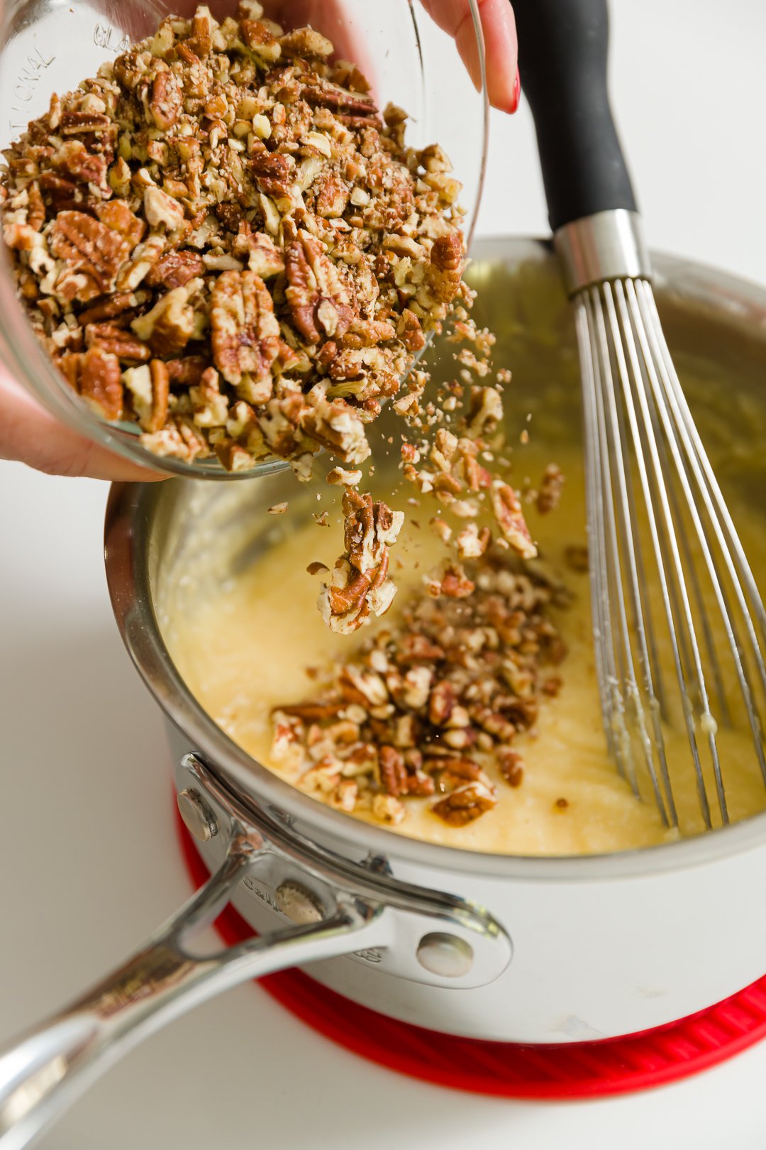 Adding chopped pecans to pot