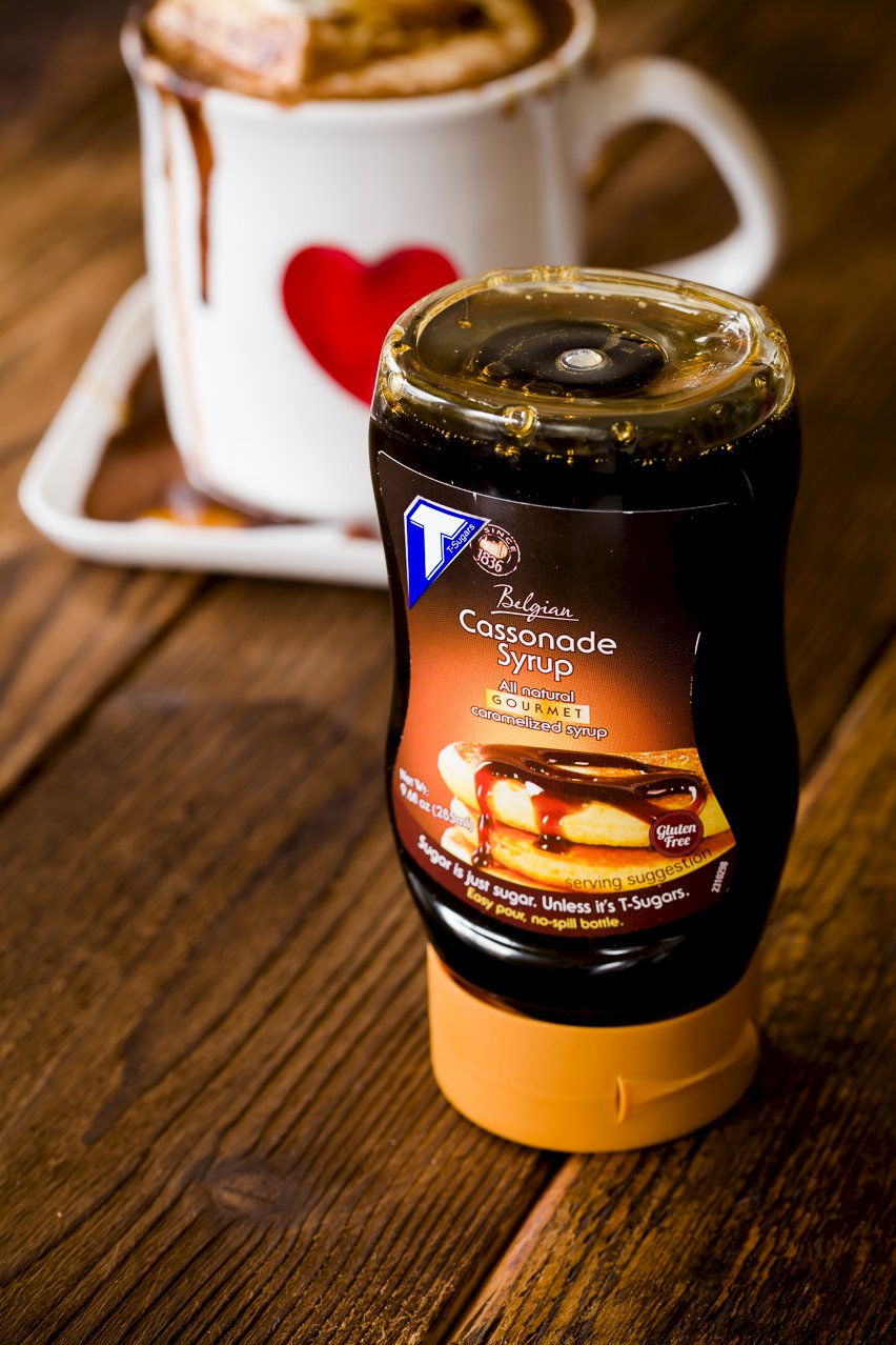 a bottle of cassonade syrup next to a mug of hot chocolate