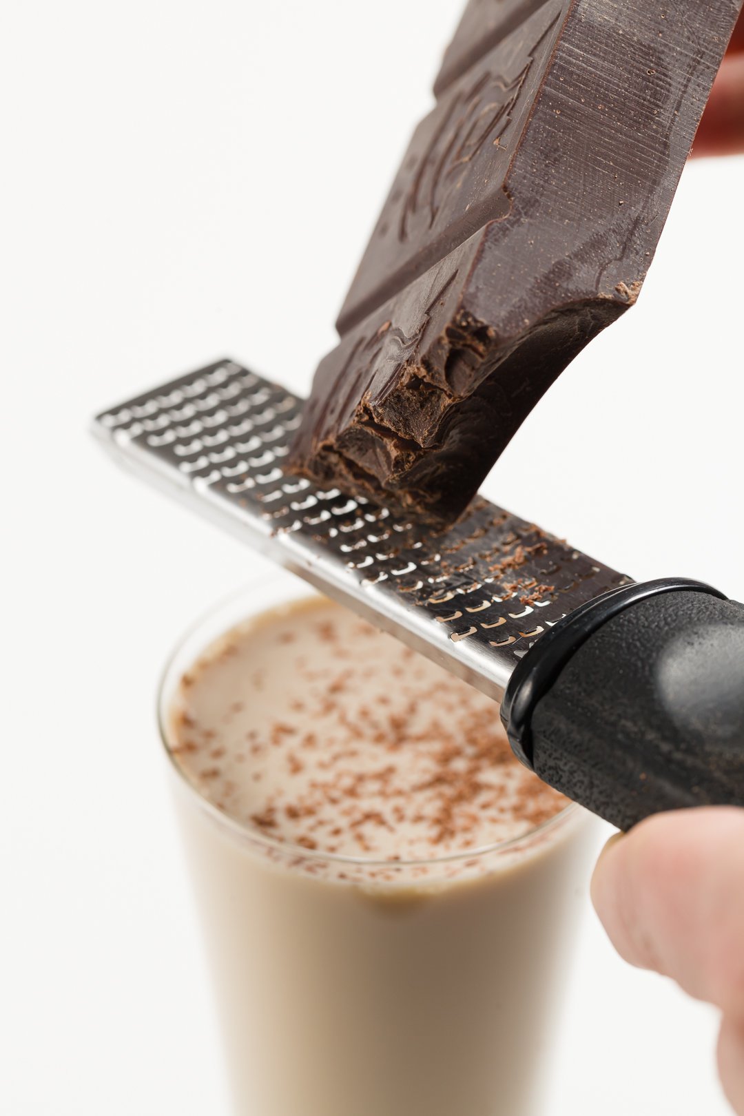 shaving chocolate on top of a mudslide cocktail in a glass