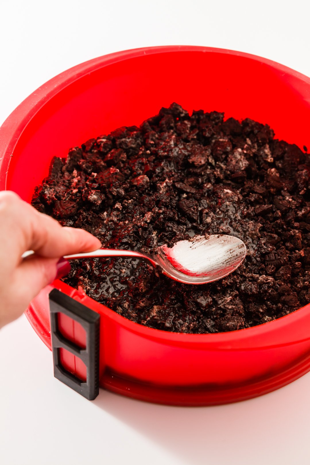 Pressing Oreo crust into a springform pan