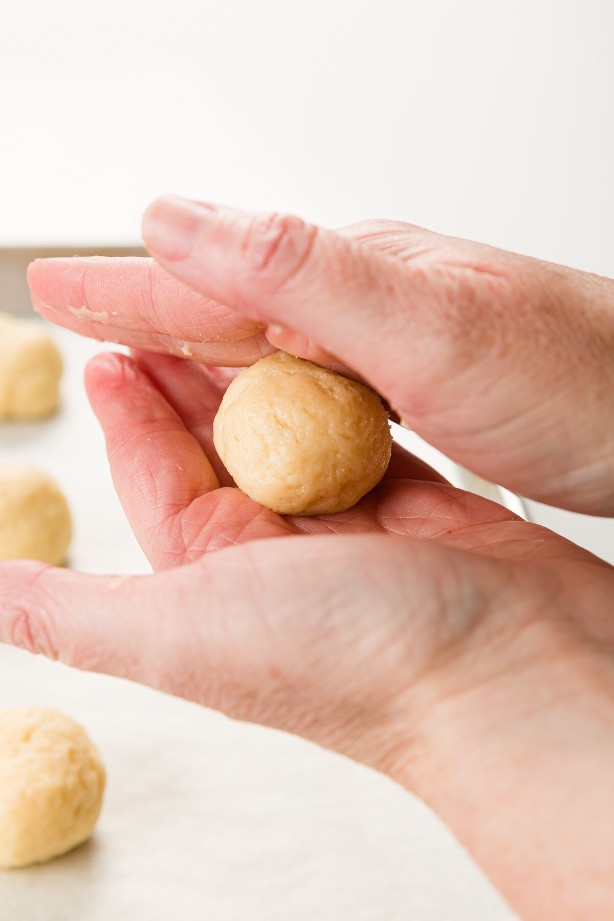Rolling cookie dough ball between two hands