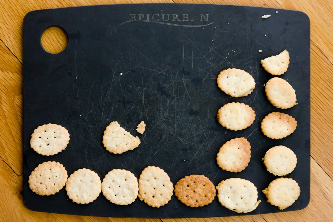 Columns of homemade Ritz cracker experiments on a cutting board