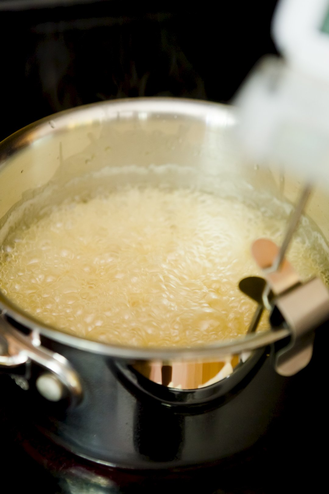 Pot of boiling taffy with a candy thermometer on it