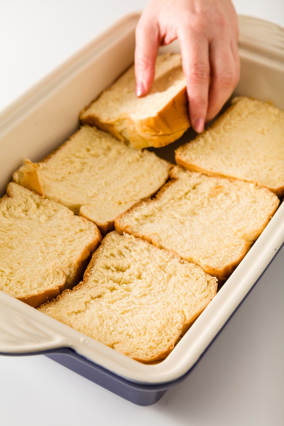 lining a casserole dish with brioche bread
