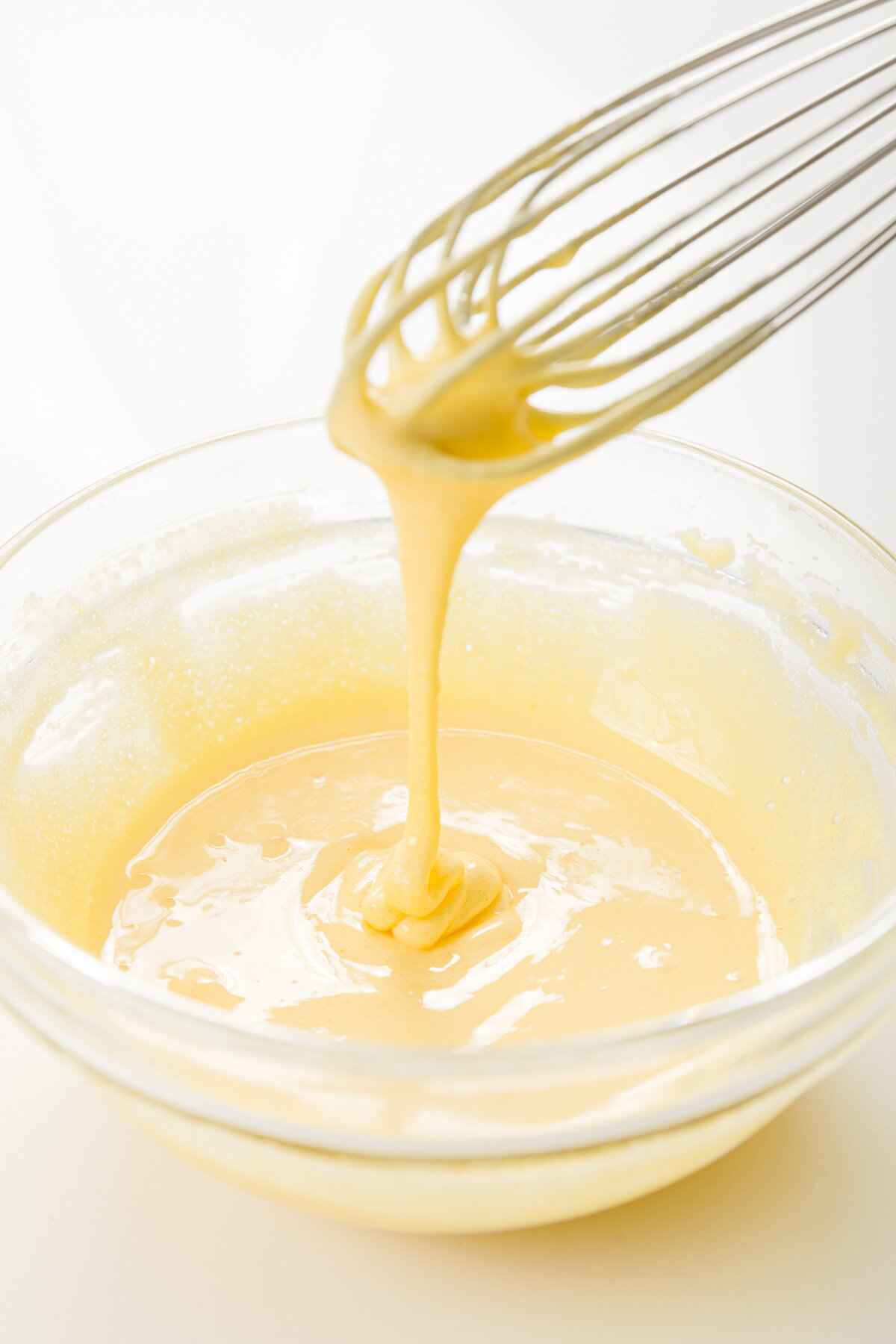 medium shot of egg yolks and sugar whisked together in a bowl until pale