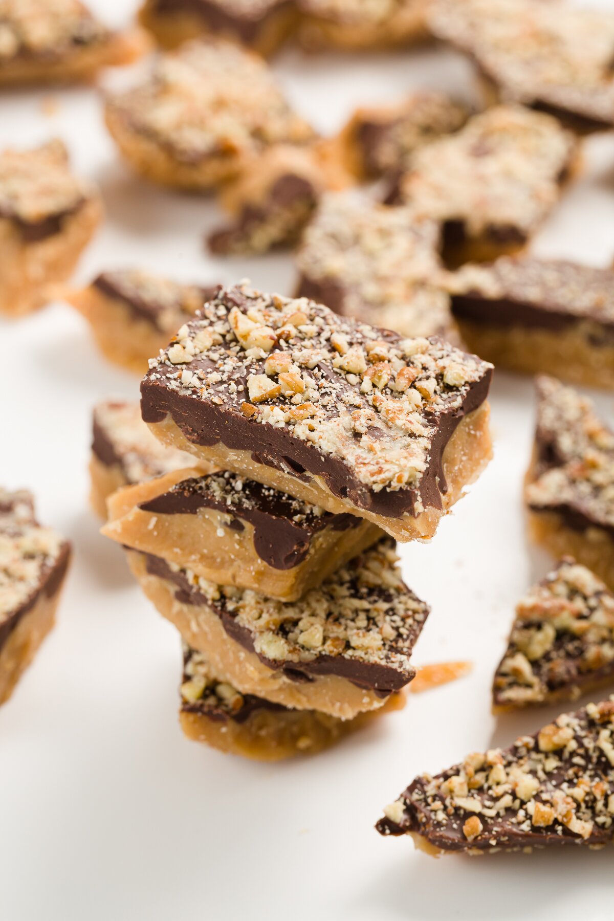 stack of 4 pieces of toffee with more toffee scattered in the background