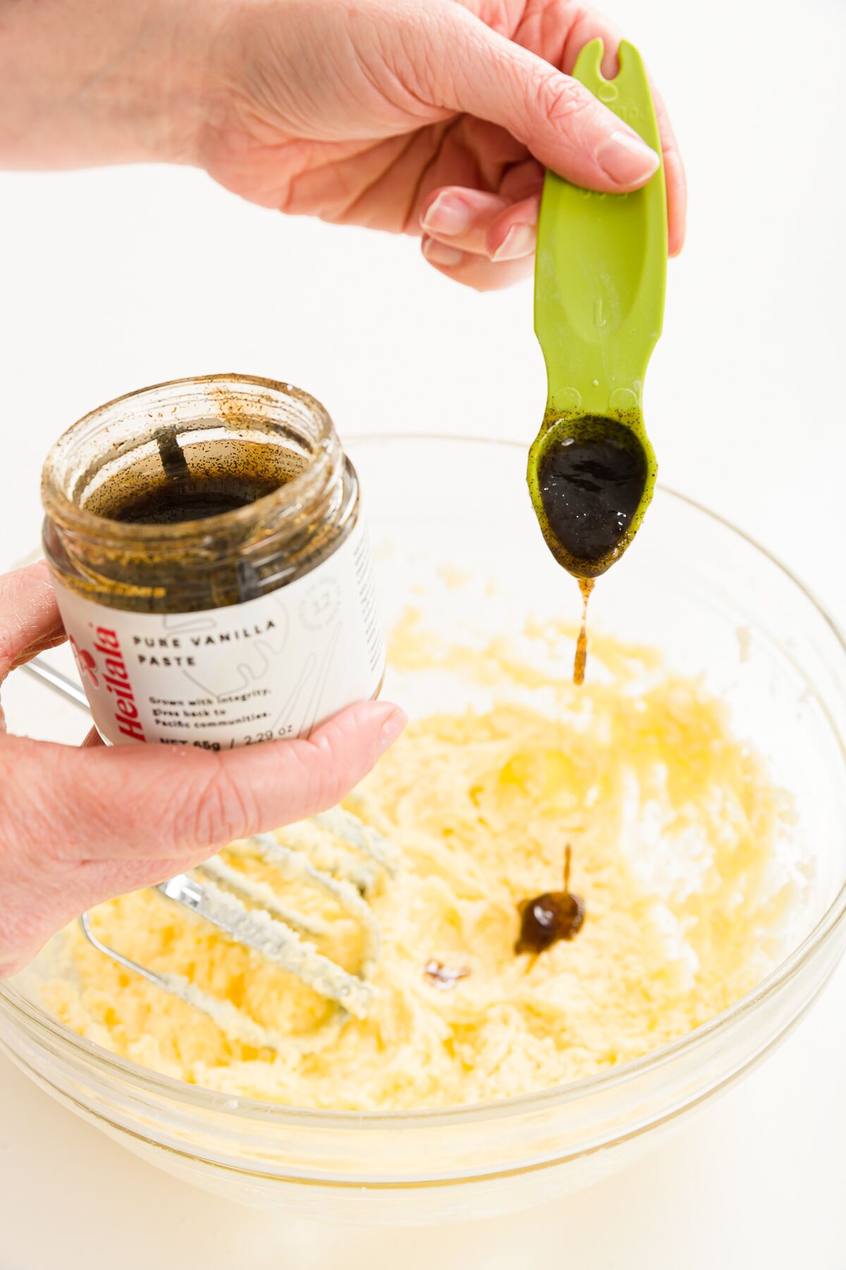 Adding vanilla bean paste to a bowl of batter